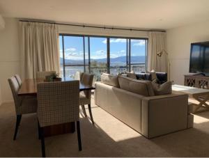 a living room with a couch and a table and a television at Lake Vista Lodge in Jindabyne
