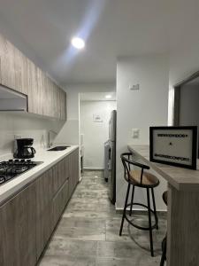 a kitchen with a counter and a stove and refrigerator at Horeb Confort in La Tebaida