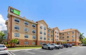 Un hotel con coches aparcados en un estacionamiento. en Extended Stay America Premier Suites - Miami - Airport - Doral - 87th Avenue South, en Miami