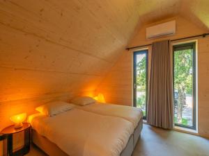 a bedroom with a bed in a wooden wall at Luxury holiday home by the sea in Sint Maartenszee