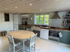 a kitchen with a table and chairs in it at 4 star holiday home in SÖLVESBORG in Sölvesborg