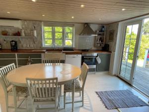 a kitchen with a wooden table and chairs at 4 star holiday home in SÖLVESBORG in Sölvesborg +27 photos