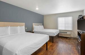 Una habitación de hotel con dos camas y un televisor. en Extended Stay America Select Suites - Phoenix - North, en John C Lincoln Helistop