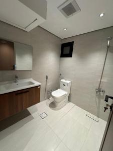 a bathroom with a toilet and a sink at أجنحة رافينا هاوس - Ravina Suites in Riyadh