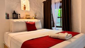 een slaapkamer met een bed met een rode handdoek erop bij Garden Hotel in Copan Ruinas