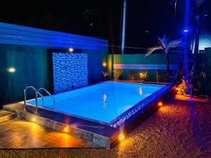 a swimming pool with lights in a house at night at Shehan Villa in Beruwala