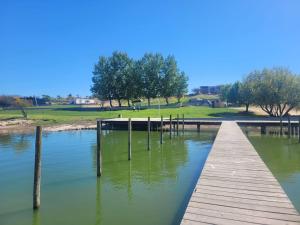 einem Holzsteg in einem Wasserkörper in der Unterkunft Casa con piscina en Condominio Lago Rapel BLQ in El Estero