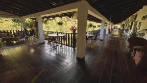 een overdekte veranda met tafels en stoelen op een terras bij Garden Hotel in Copan Ruinas
