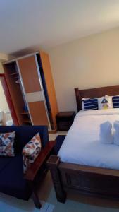 a bedroom with a bed and a blue couch at Chic Studio Apartment near Nairobi CBD in Nairobi
