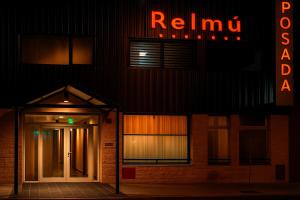 a building with a door and a neon sign at Posada Relmú in Neuquén