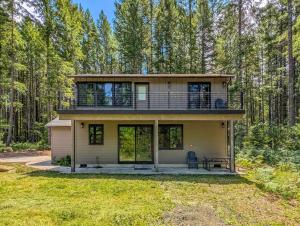 Una casa con un porche envolvente en el bosque. en River Dance Cabin, en Packwood