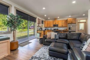 Una sala de estar con un sofá de cuero y una cocina. en River Dance Cabin, en Packwood