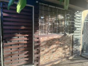 a wooden fence with a gate and a brick wall at Estancia WLC in Ayutuxtepeque