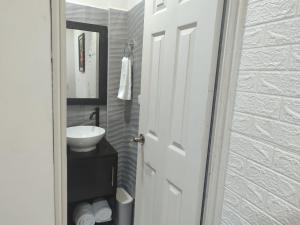 a bathroom with a white sink and a mirror at Estancia WLC in Ayutuxtepeque