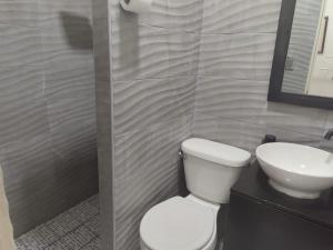 a bathroom with a toilet and a sink at Estancia WLC in Ayutuxtepeque +2 photos