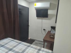 a room with a bed and a desk and a door at Estancia WLC in Ayutuxtepeque
