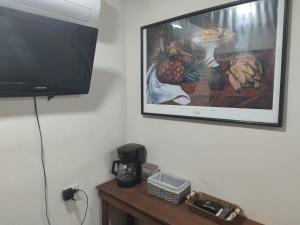 a television on a wall with a picture of a pineapple at Estancia WLC in Ayutuxtepeque