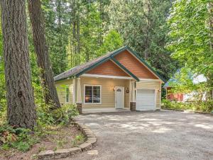 a small house with a garage in the woods at Fairway Paradise in Packwood