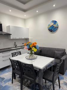 カターニアにあるNaomi Luxury Home 2の花瓶に花が飾られたテーブルのあるキッチン