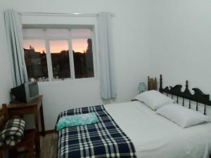 un dormitorio con una cama y una ventana en Pousada Sâo Luiz, en Poços de Caldas 10 fotos más