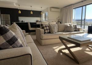 a living room with two couches and a table at Lake Vista Lodge in Jindabyne +11 photos