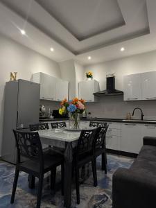 カターニアにあるNaomi Luxury Home 2の花瓶に花が飾られたテーブルのあるキッチン