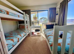 two bunk beds in a room with a window at Lake Vista Lodge in Jindabyne