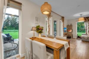 una sala da pranzo con un tavolo e un soggiorno di The Flower Nest a Zvejniekciems