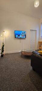 a living room with a couch and a tv on the wall at OG Stays V in Pallion