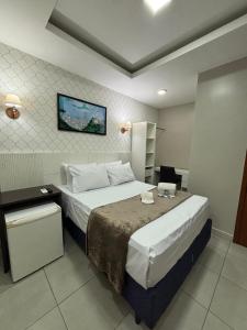 ein Schlafzimmer mit einem großen Bett in einem Zimmer in der Unterkunft Suites Flamengo in Rio de Janeiro