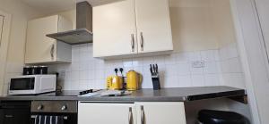 a kitchen with white cabinets and a counter top at OG Stays V in Pallion +7 photos