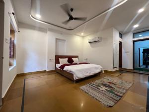 Un dormitorio con una cama con ventilador de techo. en Prem baba Haveli, en Jaisalmer