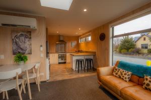 a living room and kitchen with a couch and a table at Starlight Townhouse in Twizel