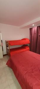two beds in a room with red sheets at El Descanso Pampa in Santa Rosa