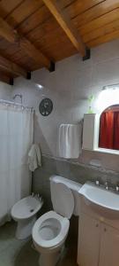 a bathroom with a toilet and a sink at El Descanso Pampa in Santa Rosa