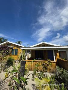 a house on the beach with a fence at Garden Reef Bungalows in Vitouara +9 photos