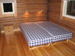 a bed in the corner of a room at Pitkäniemen Lomamökit in Joutsa