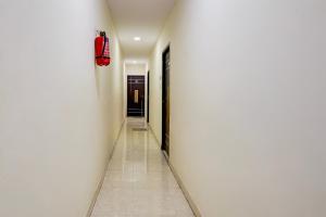a hallway with a white wall and a red bag on the wall at Collection O Thousand Lights Chennai in Chennai