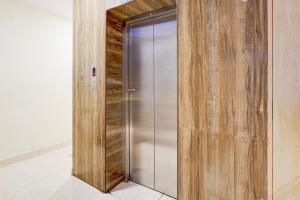 a metal elevator in a room with wooden walls at Collection O Thousand Lights Chennai in Chennai