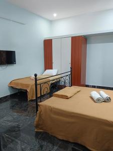 two beds in a room with a desk and a mirror at Perumal home stay in Tiruvannāmalai