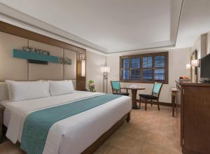 a hotel room with a bed and a table and chairs at Henann Regency Resort and Spa in Boracay