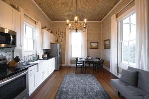 a large kitchen with a table and a chandelier at The Cahill- Magnolia Brewery House c 1894 in Waco