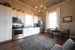a kitchen with white cabinets and a table and a chandelier at The Cahill- Magnolia Brewery House c 1894 in Waco