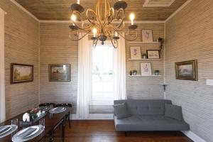 a living room with a couch and a table and a chandelier at The Cahill- Magnolia Brewery House c 1894 in Waco +14 photos