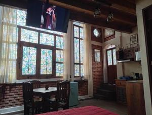 a dining room with a table and some windows at "Arte en el desván" Rustic loft - Desván rústico in Tenancingo de Degollado