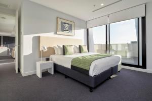 um quarto com uma cama grande e uma janela grande em 381 Cremorne em Melbourne