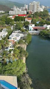 an aerial view of a river with buildings and trees at Edificio Sierra Beach Resort Pozos Colorados vista y salida al mar in Santa Marta