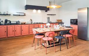 cocina con mesa de madera y sillas rosas en Ravissante Maison Bretonne, en Pleumeur-Gautier