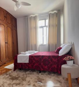 a bedroom with a red bed and a window at Apartamento inteiro 2 quartos Porto Barra Vista Mar in Salvador