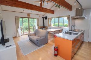a kitchen and living room with a couch and a sink at 南伊豆ガーデンヴィラ in Minamiizu